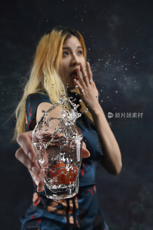女子手持溅水玻璃杯瞬间