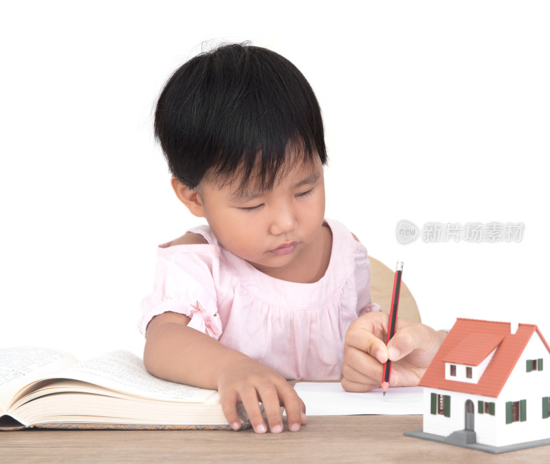 黄皮肤小女孩在学习及旁边还放着小房子模型