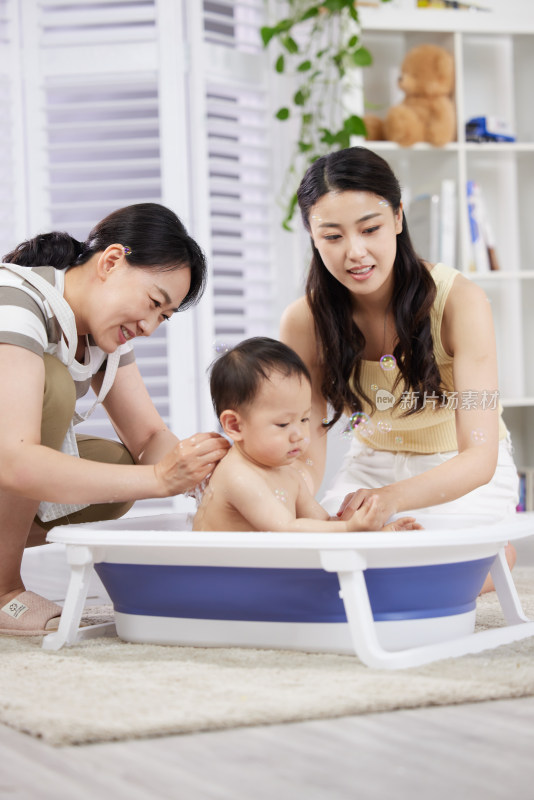 月嫂和年轻妈妈一起照顾宝宝洗澡