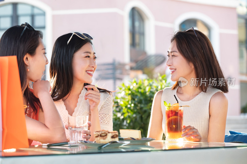 青年女人坐在露天咖啡馆聊天