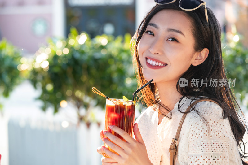 快乐的青年女人拿着夏日饮品