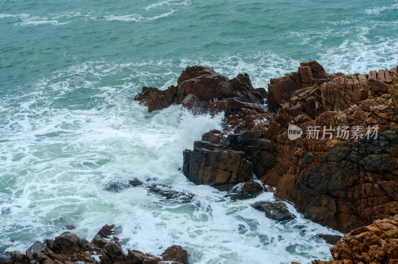 在礁石旁飞溅的浪花瞬间特写