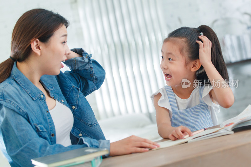 辅导女儿做作业的青年女人