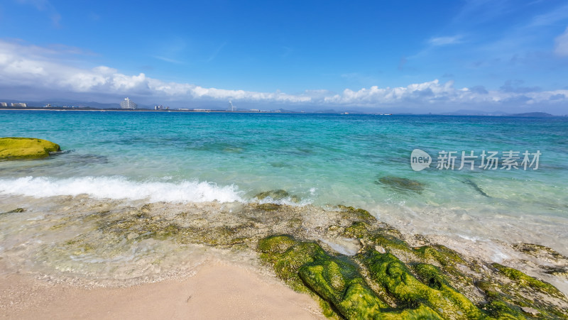 阳光下的海南三亚海岸线上礁石沙滩海浪浪花