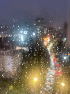 雨夜窗外城市灯光与雨水交织的景象