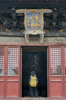 背着背包的人站在正定隆兴寺古建筑门前