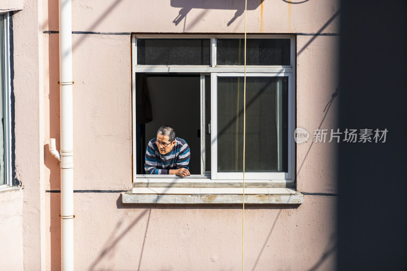 老人从窗户探出头的生活场景