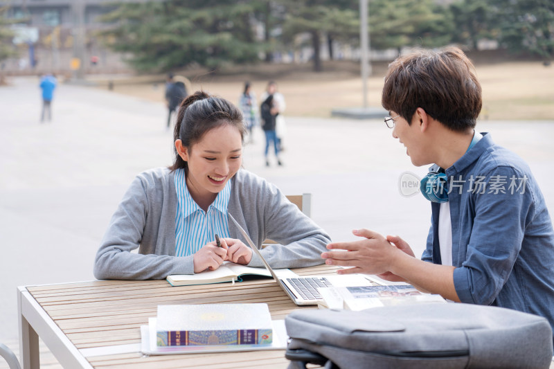 大学生情侣在校园里学习