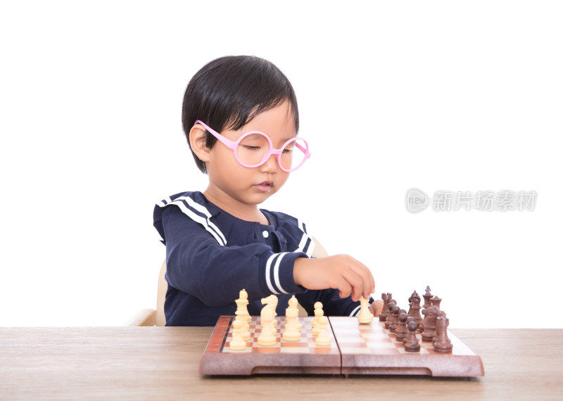 戴着眼镜框的中国小女孩在认真的下国际象棋