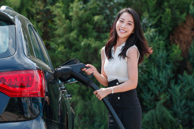 漂亮的青年女人给汽车充电