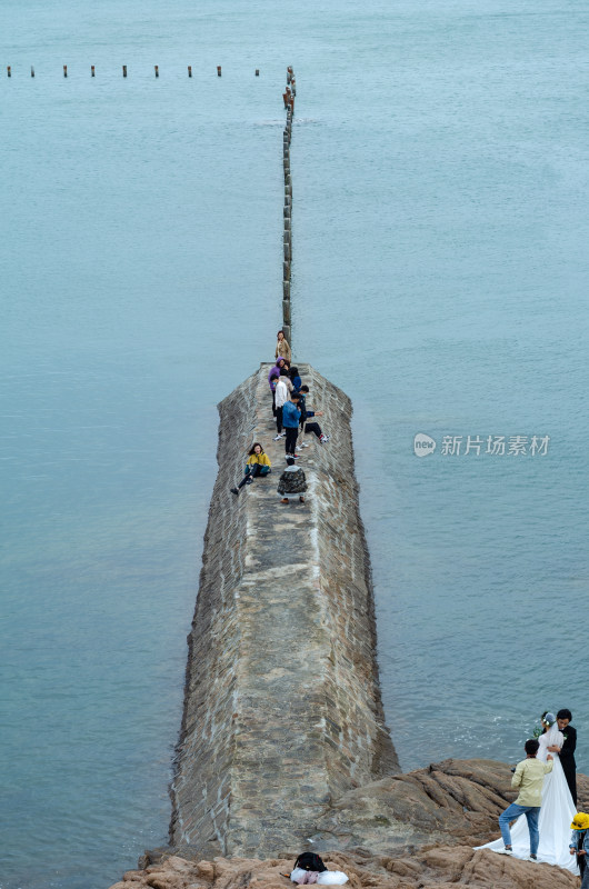 青岛第二海水浴场的大坝上有游客拍照