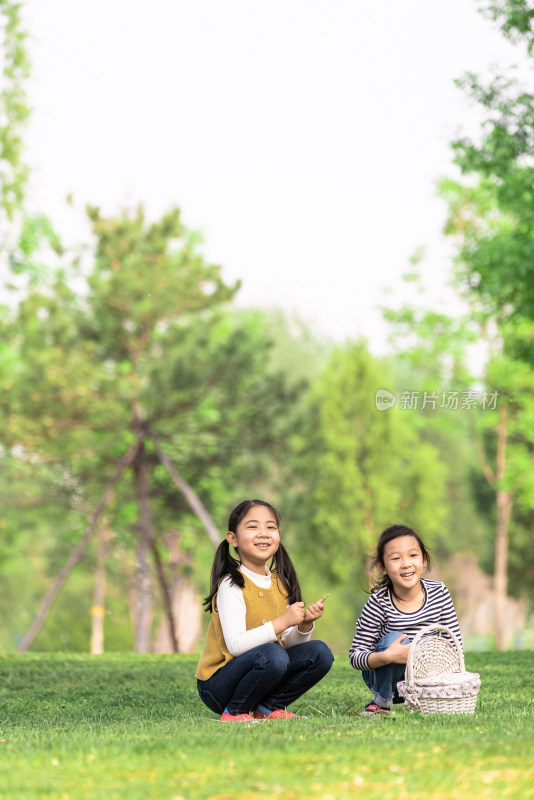 两个坐在树下玩拍手游戏的女孩