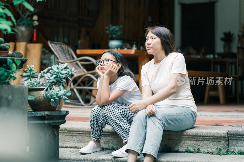 母女俩坐在石阶上神情放空的画面