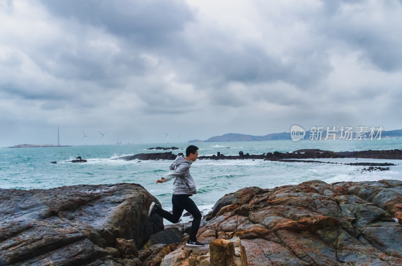 海边岩石上奔跑的人