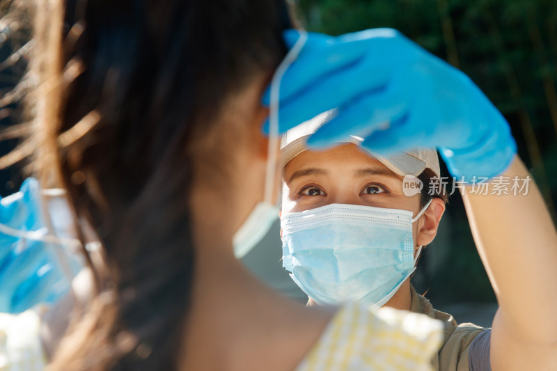 社区志愿者帮小女孩戴口罩