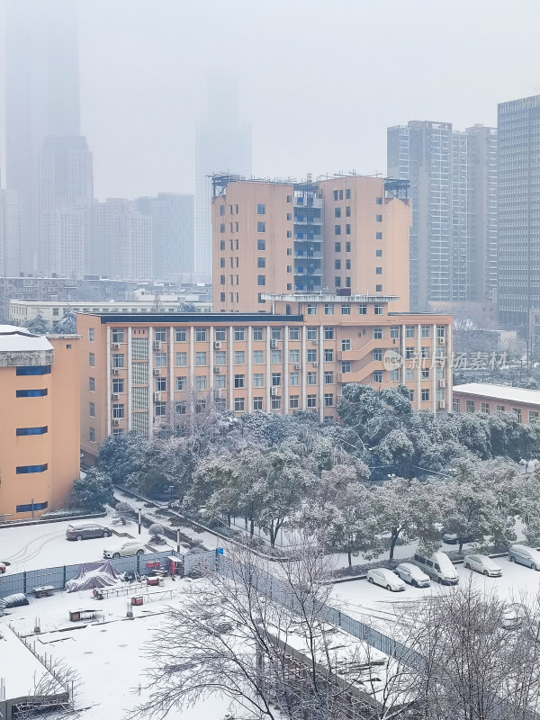 城市中雪后景象，积雪覆盖的建筑与车辆