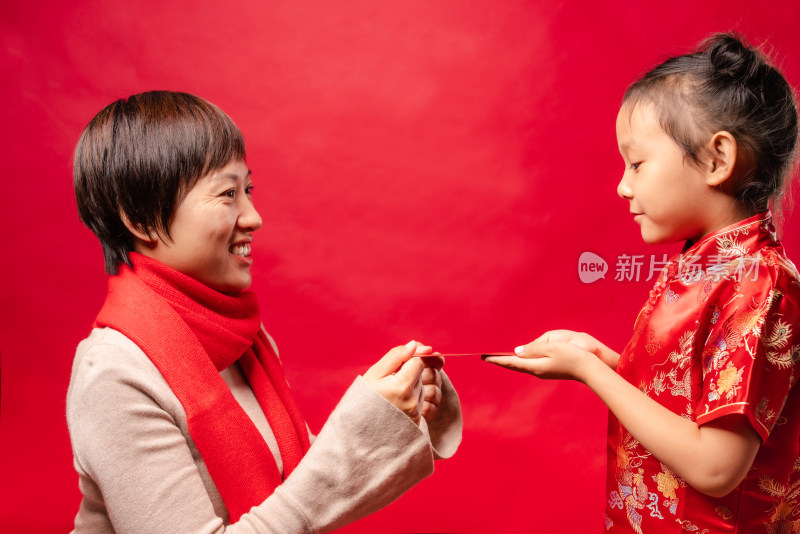 站在红色背景前接受红包的中国女孩