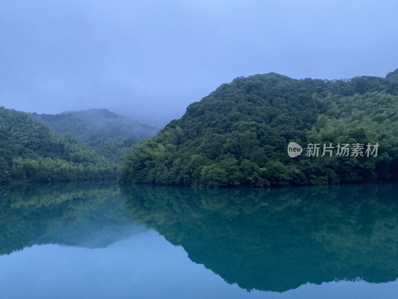 平静的绿水倒映着雾气氤氲的青山