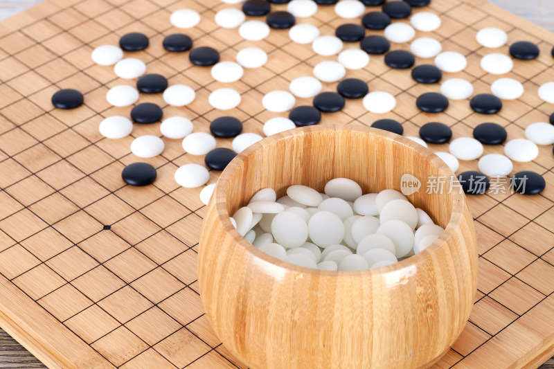 棋盘上散落的棋子和装满棋子的木盒