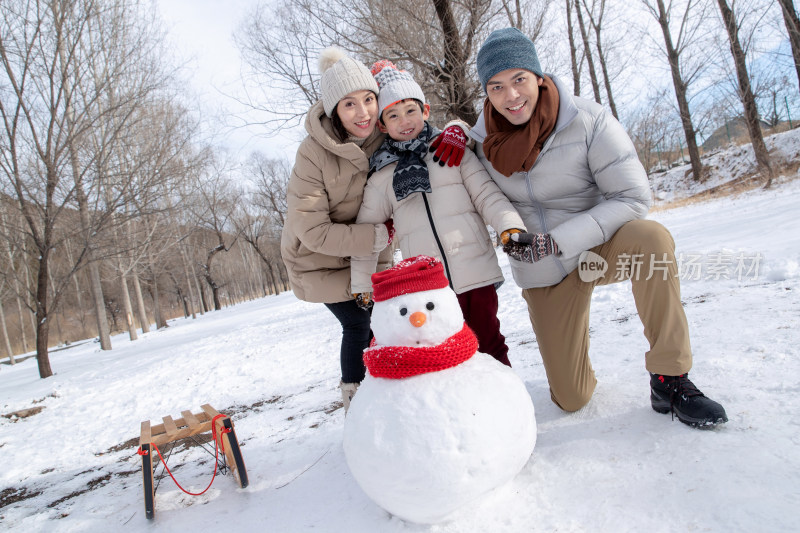 一家三口在雪地里堆雪人