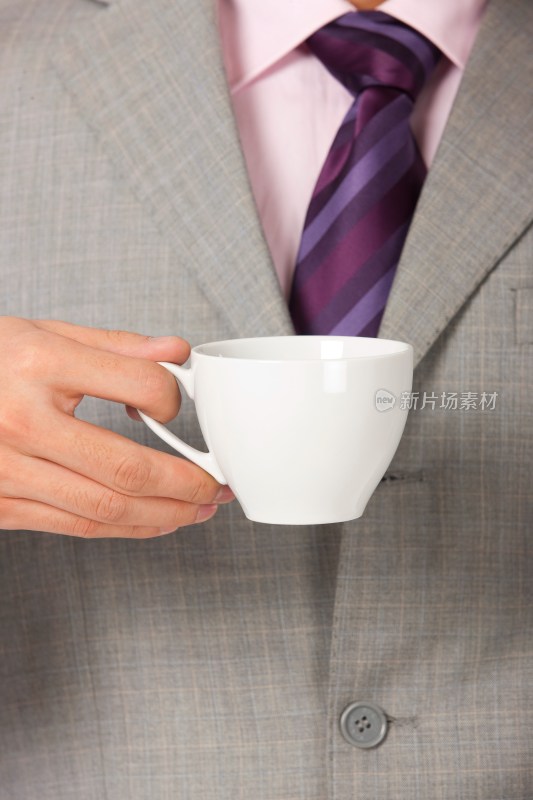 商务男士端着咖啡杯
