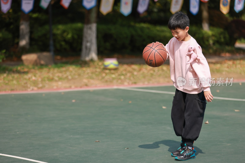 亚洲男孩在篮球场打篮球