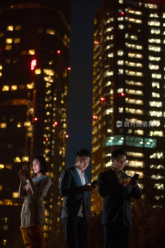 夜晚在户外使用手机的商务团队