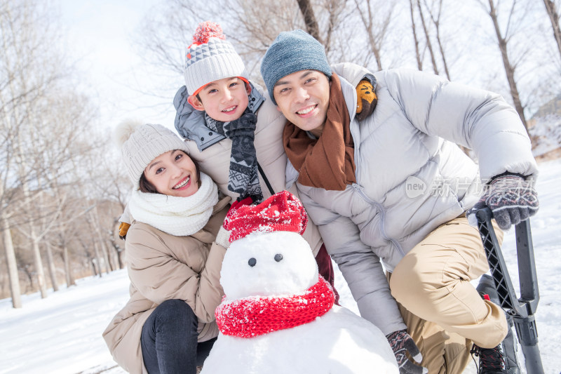 一家三口在雪地里堆雪人