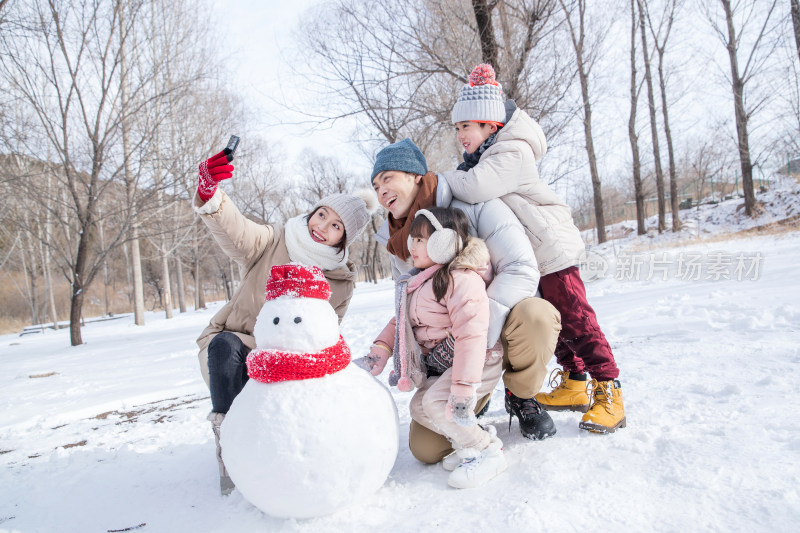 欢乐家庭在雪地里堆雪人