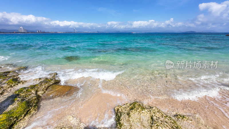 阳光下的海南三亚海岸线上礁石沙滩海浪浪花