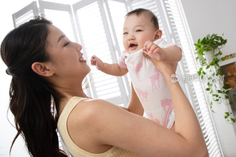 年轻妈妈抱着宝宝玩耍