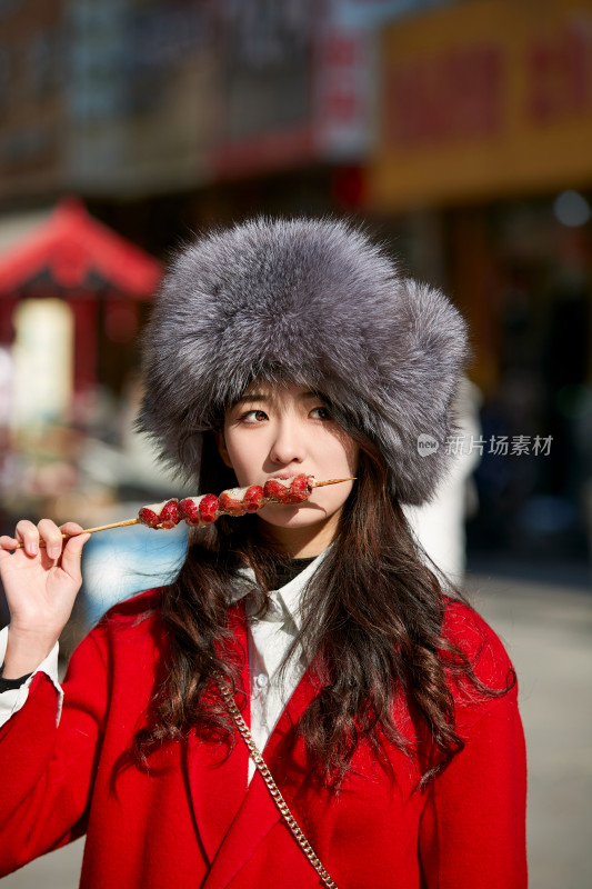 穿着喜庆服饰吃糖葫芦的美丽少女