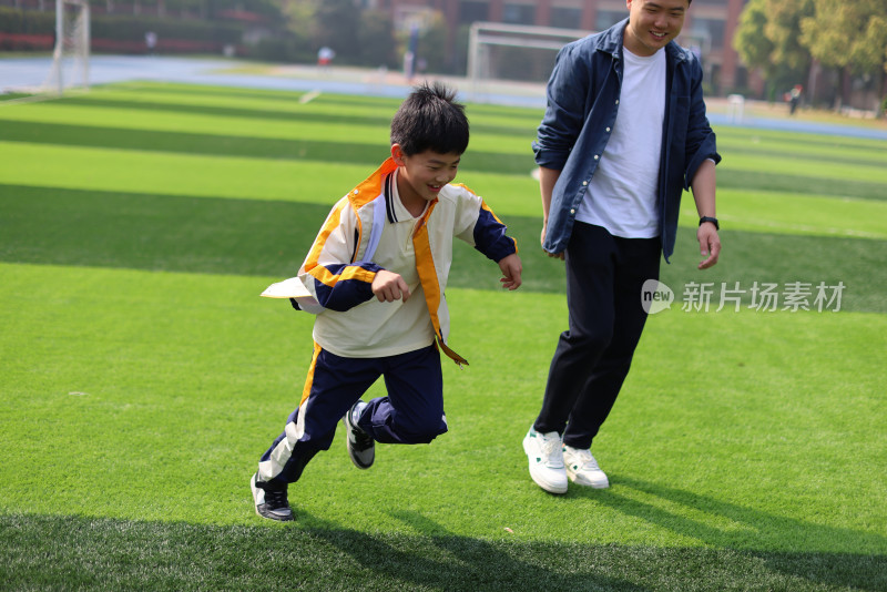 父亲和儿子在足球场上踢球