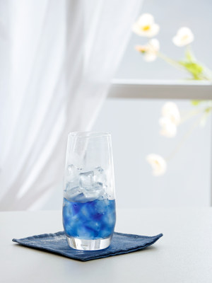 白色桌面上的一杯夏日蓝色饮品