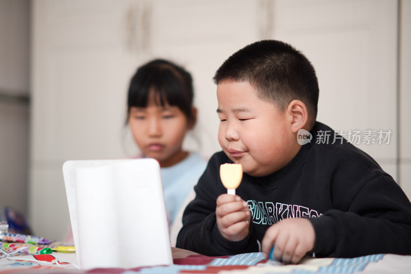 肥胖男孩吃着东西和小女孩一起看电影