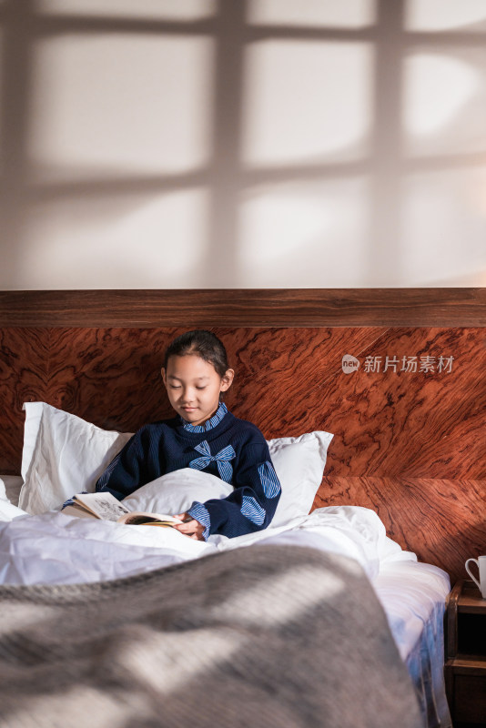 坐在床上认真看书的中国女孩