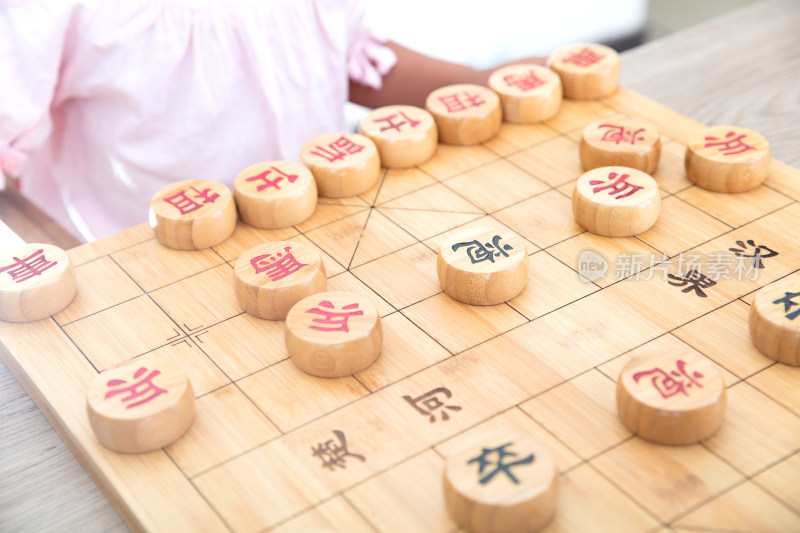 小女孩在和妈妈下中国象棋