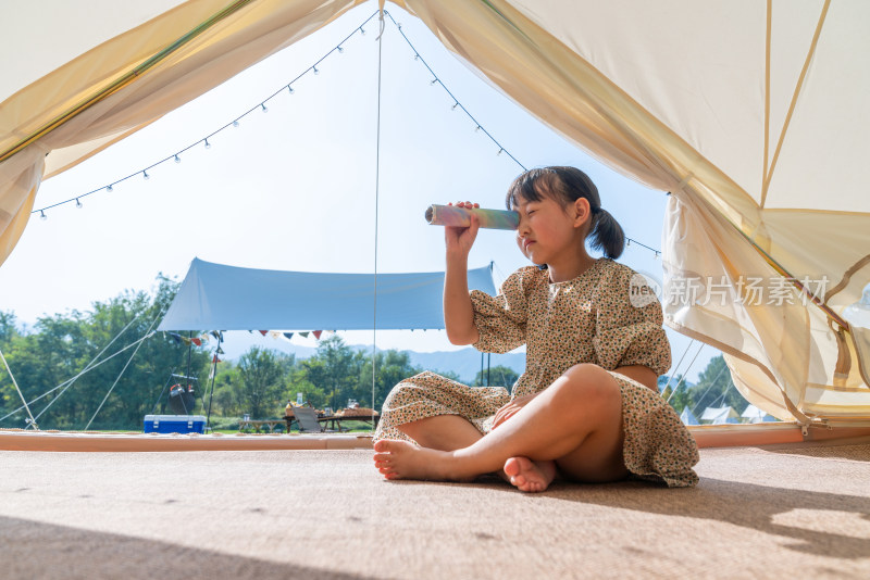 一个女孩坐在帐篷里玩耍