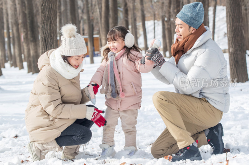 一家三口在雪地里玩耍