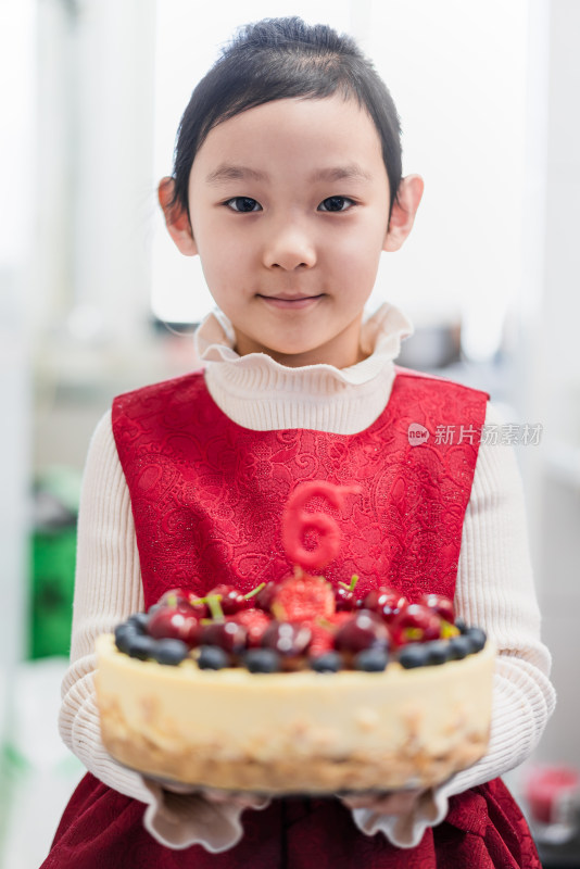 中国女孩手捧刚制作完成的生日蛋糕