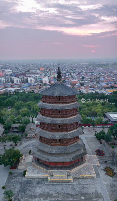 暮色下的古塔及周边城镇全景