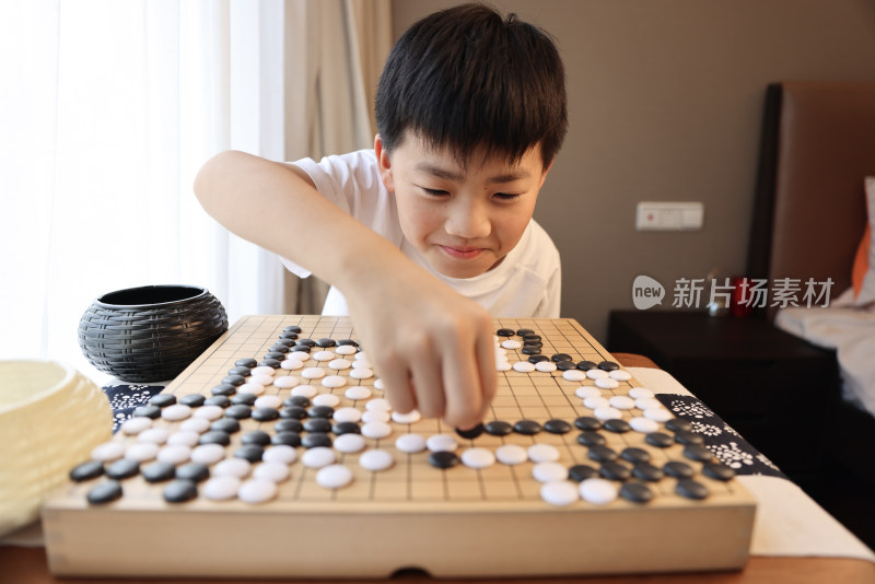 可爱的男孩在窗边下围棋