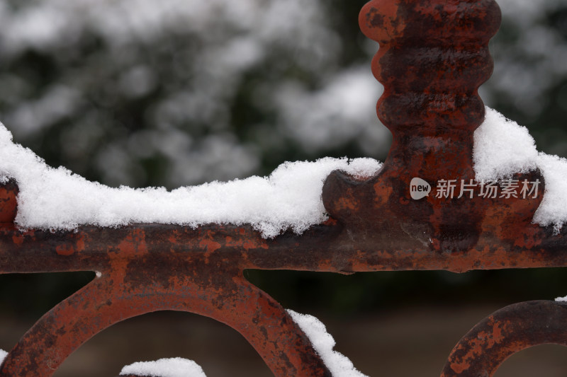 围墙的金属栅栏上堆积着洁净的白雪