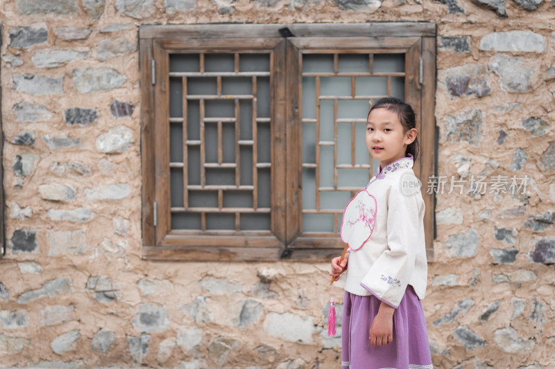 穿中国传统服饰走在古院落街道上的女孩