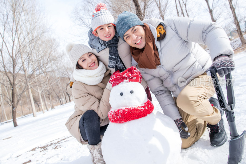 一家三口在雪地里堆雪人