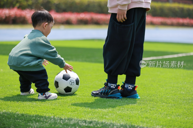 两个男孩在足球场踢足球