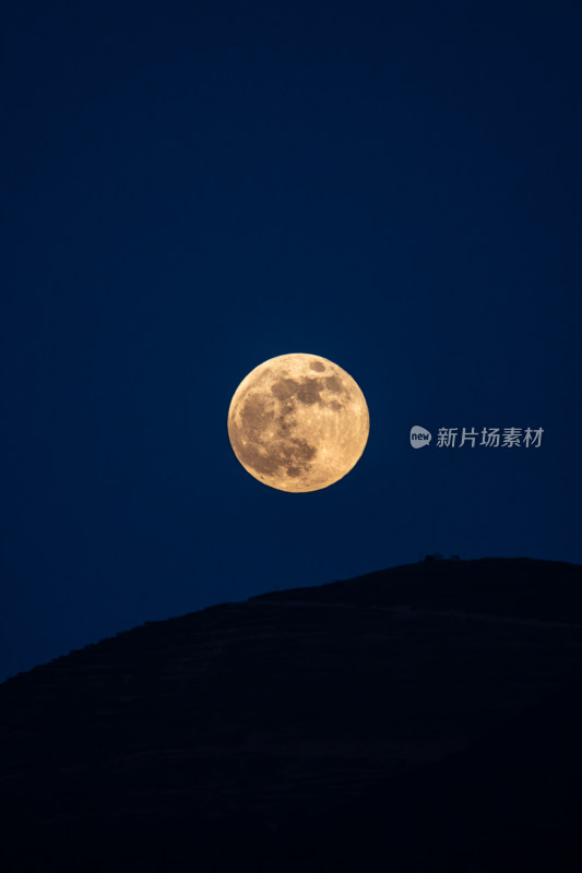 夜空下山顶上的一轮满月