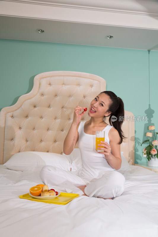 年轻女人在卧室里吃早餐