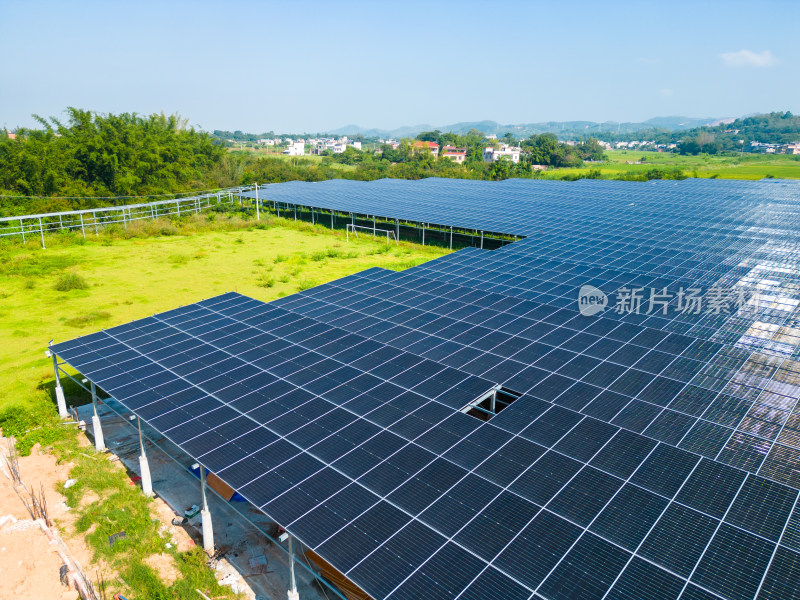 航拍俯瞰绿色乡村搭建好的光伏板太阳能发电