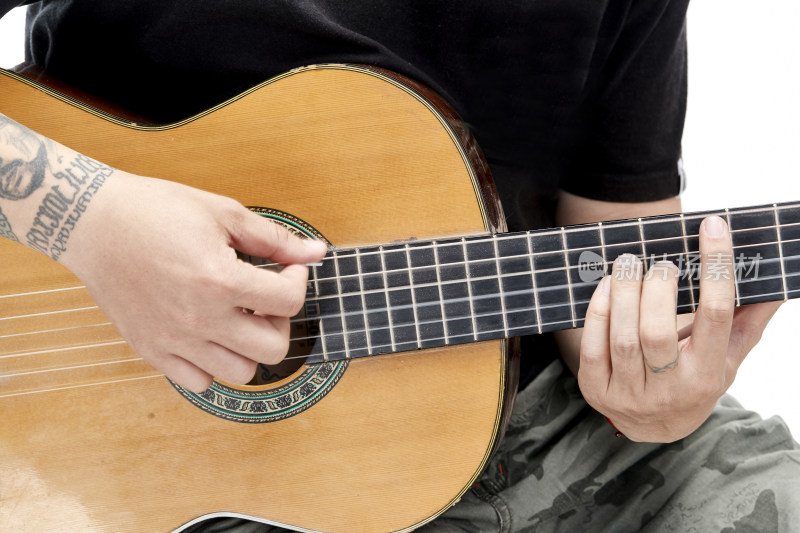 示范演奏古典吉他的亚洲男性乐手人像局部特写